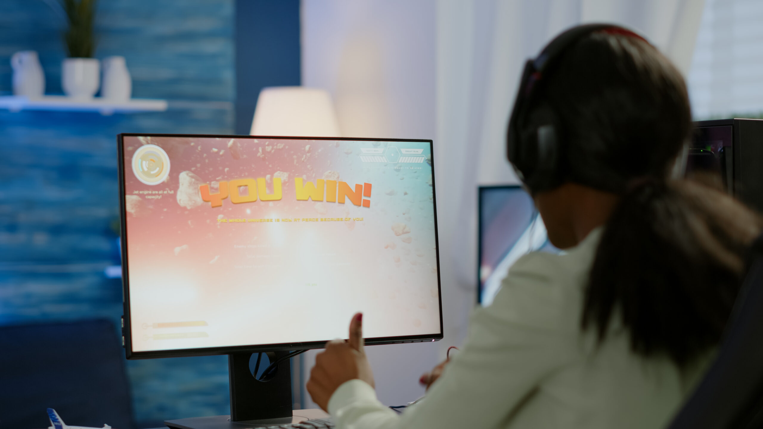 Excited black esport gamer celebrating championship victory, woman winning space shooter video game. Pro cyber gaming online tournament live streaming championship using RGB powerful computer